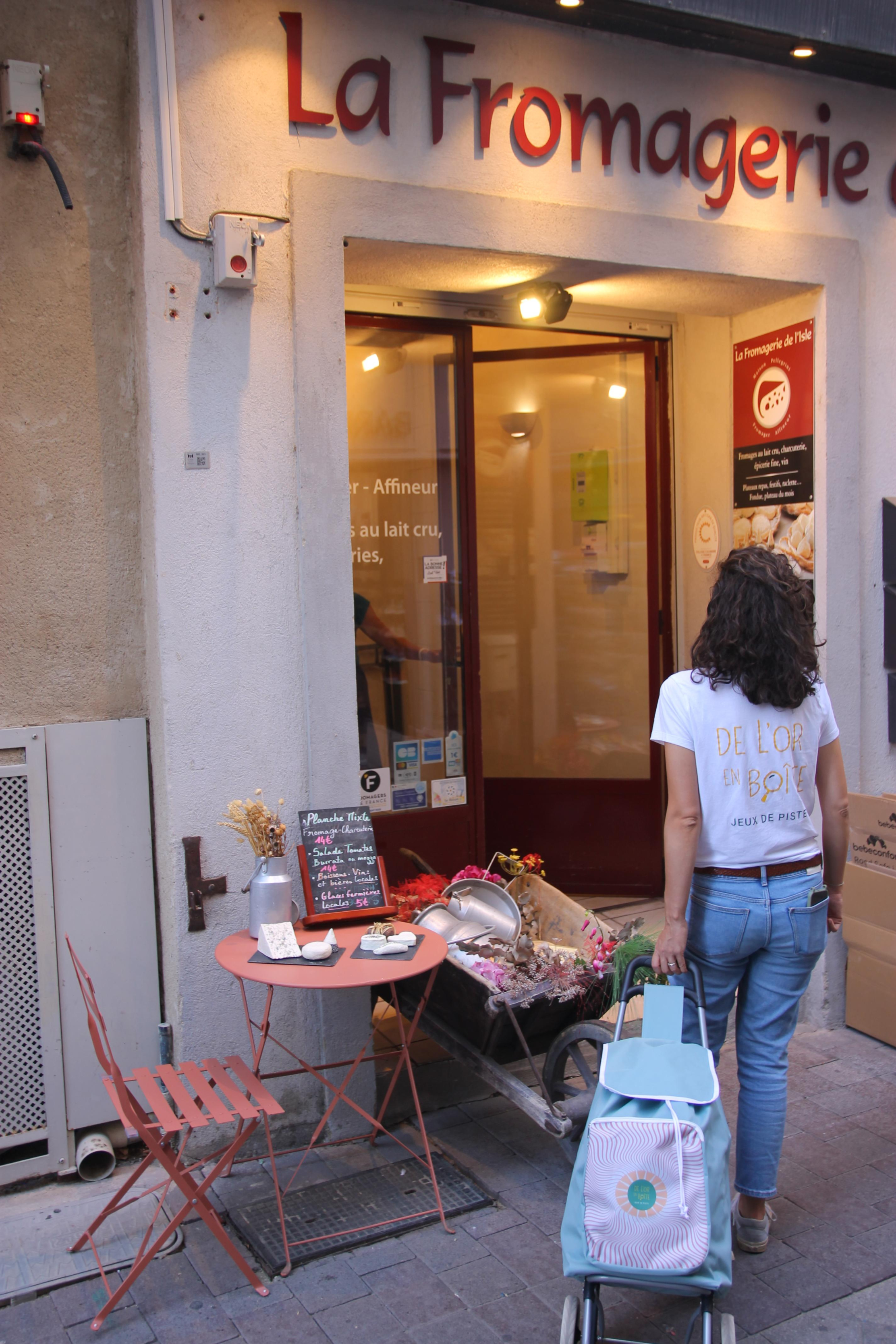 Eine von hinten gesehene Frau, die einen Einkaufswagen trägt und in Richtung geht