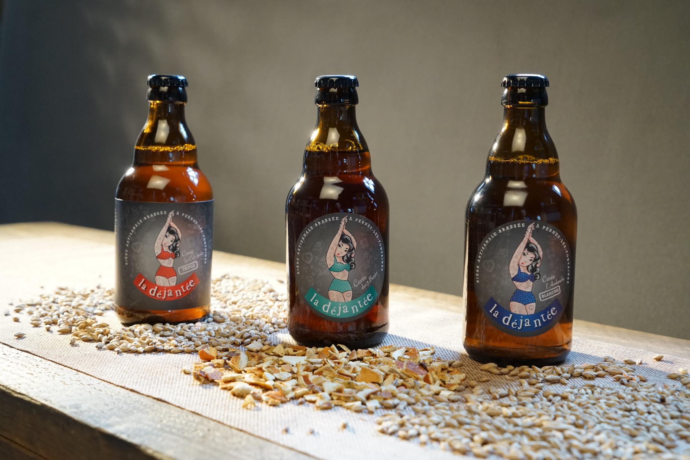 Drei Flaschen Bier auf einem Tisch mit Müsli.