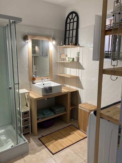 Badezimmer mit weißer und hölzerner Dusche.