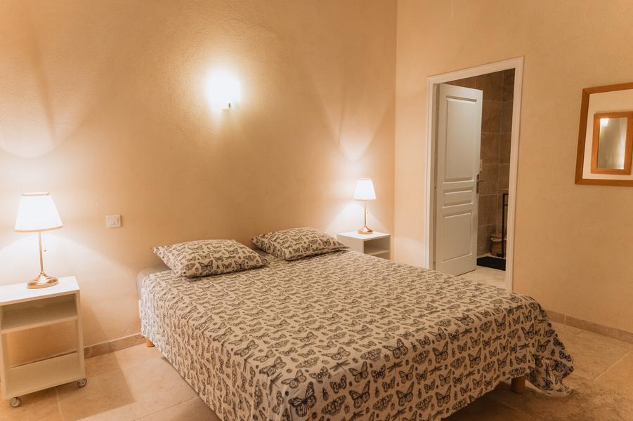 Beiges Einzelzimmer mit Doppelbett.