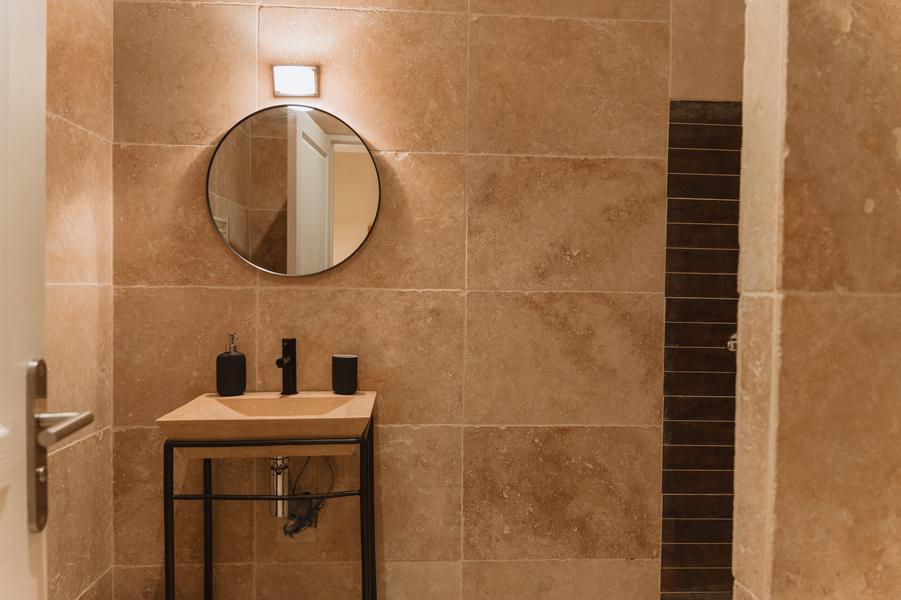 Badezimmer mit Einzelwaschbecken und Spiegel