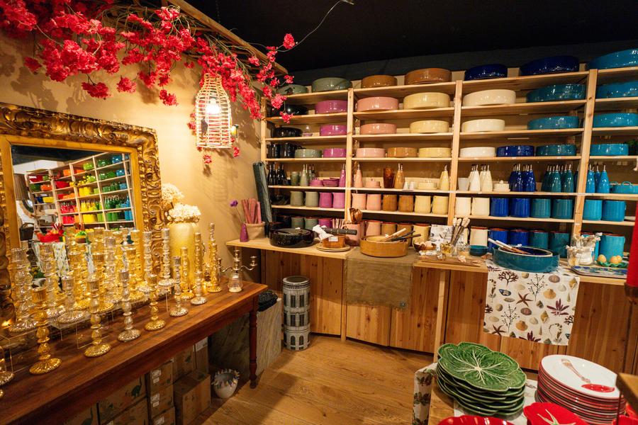 Innenraum des Ladens: Teller in verschiedenen Farben, Kerzenständer...