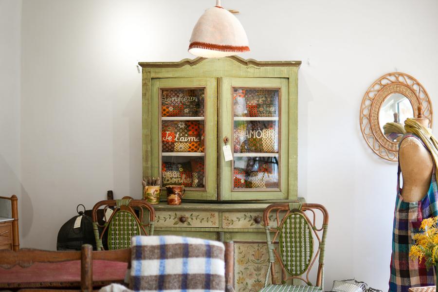 Antike grün melierte Möbel mit Rattanstühlen davor