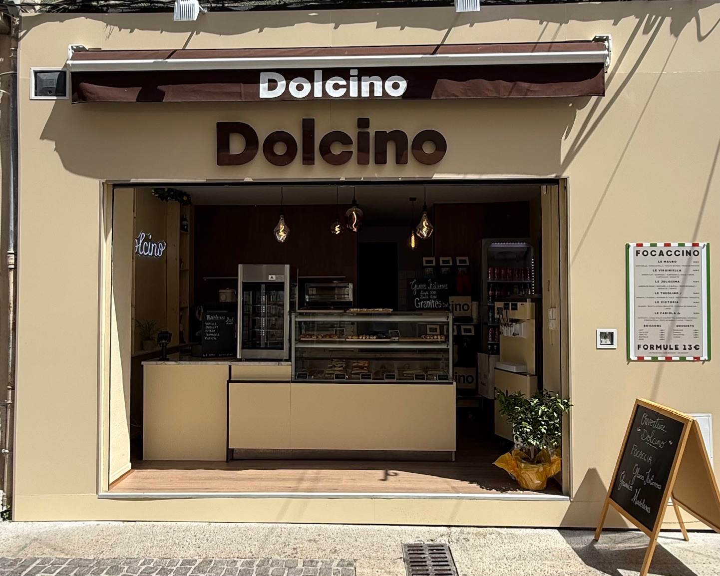 Fassade von Dolcino im Stadtzentrum, italienischer Sandwichladen, der Focaccias, Desserts und Gourmetspezialitäten in einer warmen Atmosphäre anbietet.