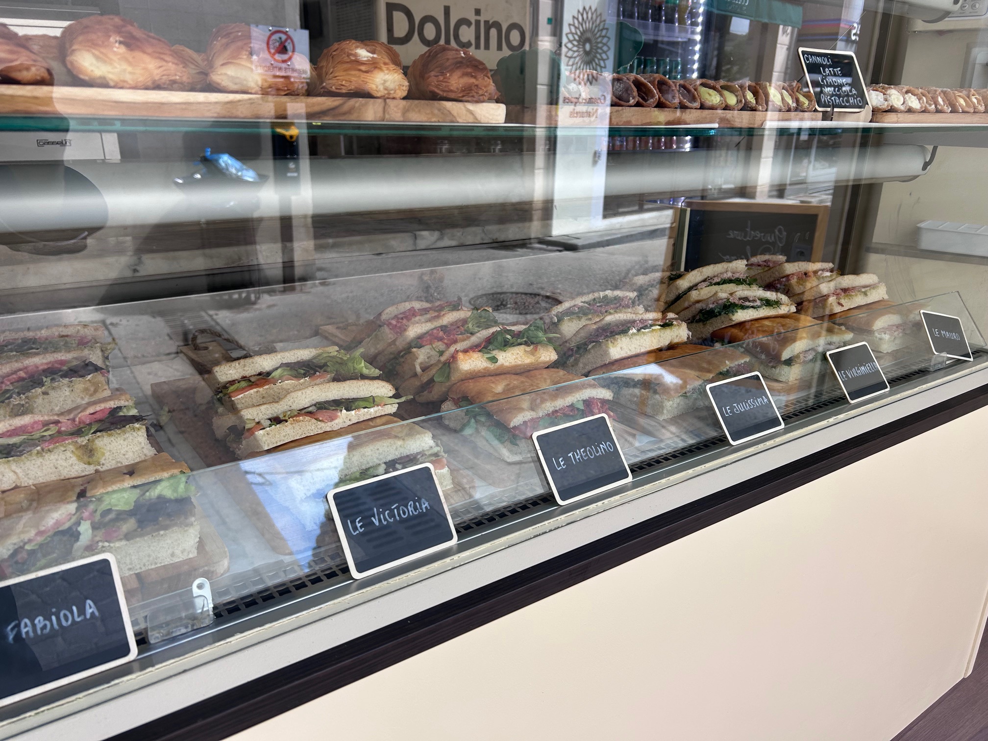 Das Gourmetfenster von Dolcino serviert gefüllte Focaccias, italienische Sandwiches und handgemachtes Gebäck für eine herzhafte oder süße Pause.