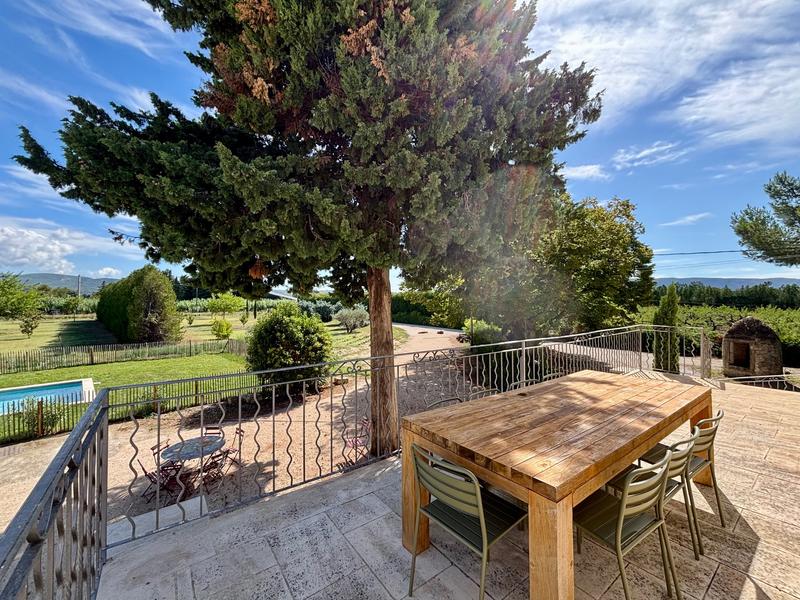 Große Terrasse mit freiem Blick auf den Garten und die provenzalische Landschaft, ideal für Mahlzeiten im Freien und entspannende Momente.