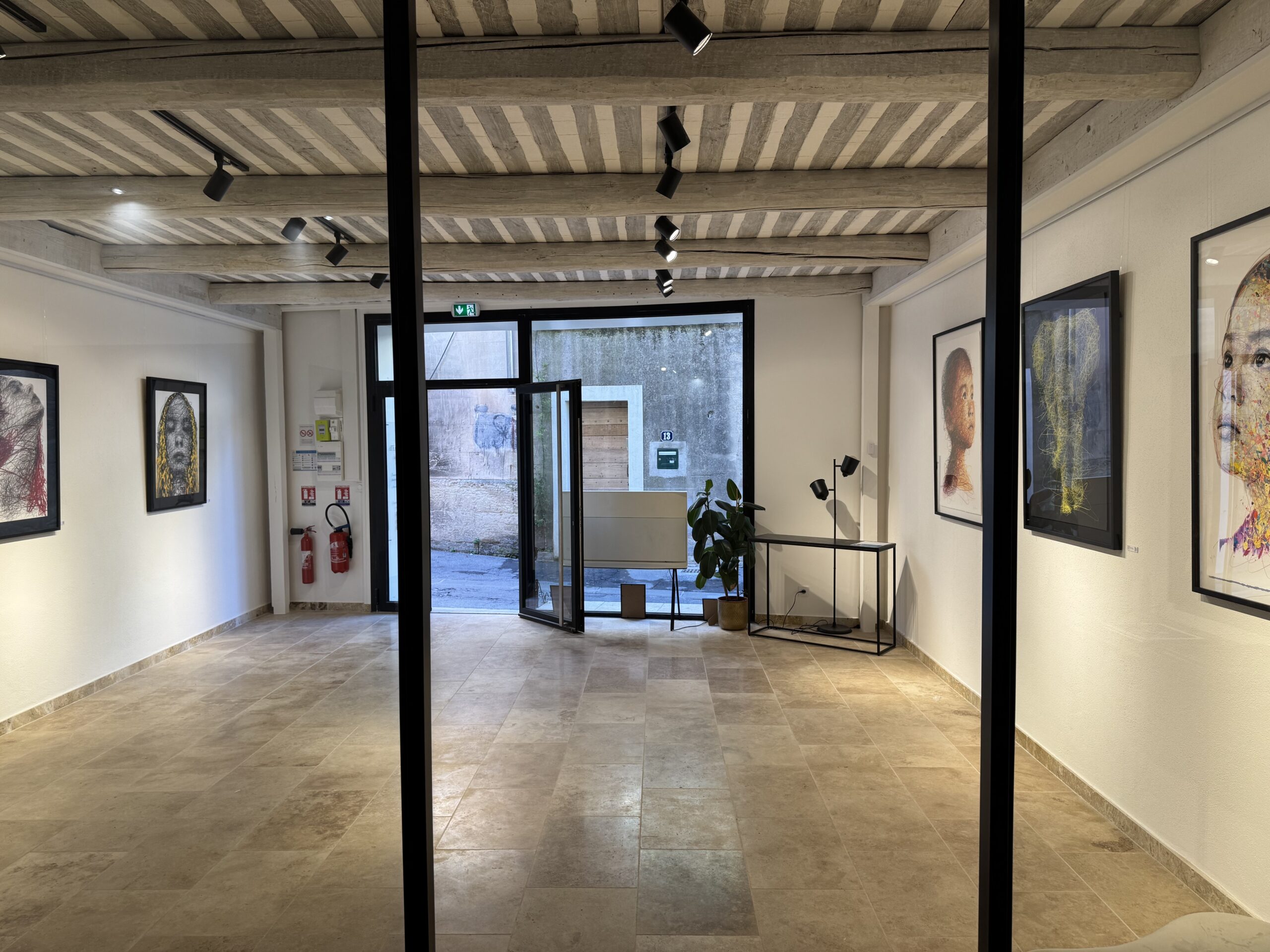 Sobald Sie eintreten, enthüllt Demeure Privée einen hellen und minimalistischen Raum, in dem provenzalische Architektur mit zeitgenössischer Kunst interagiert. Die freiliegenden Holzbalken und die natürlichen Farben des Bodens schaffen eine warme Atmosphäre, die die ausgestellten Werke hervorhebt. Das raffinierte Layout fördert die Flüssigkeitszirkulation und lädt die Besucher ein, jede Kreation in einer ruhigen und intimen Umgebung zu entdecken.