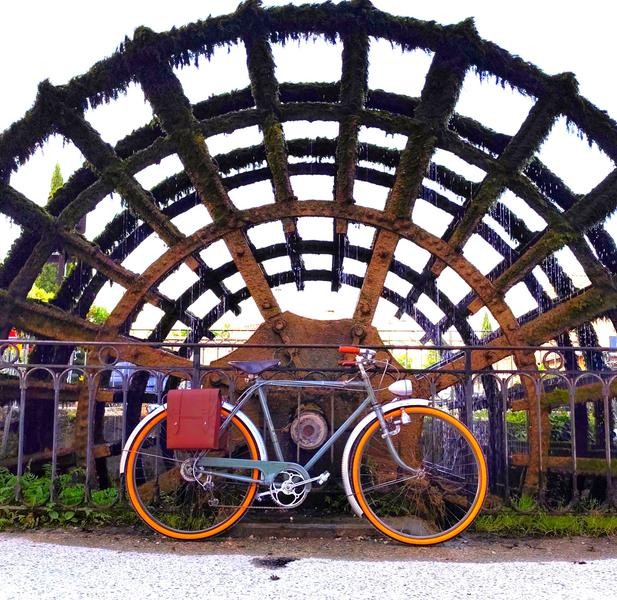 Ein antikes schwarzes Citybike wird vor einem Schaufelrad fotografiert, ein Symbol für das Erbe von L..