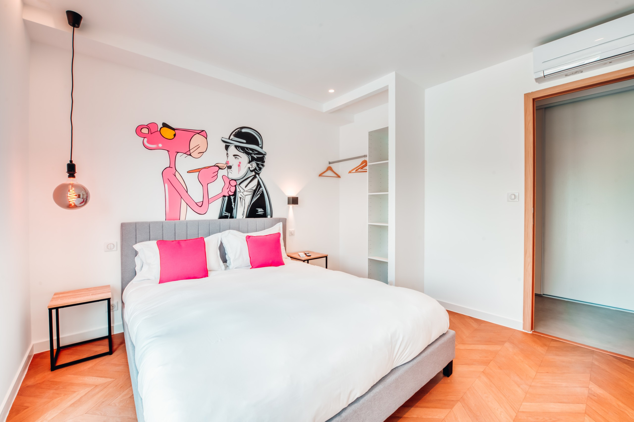 Klimatisiertes Doppelzimmer mit einer poppigen und skurrilen Atmosphäre, dekoriert mit einem großen Wandfresko mit dem Pink Panther und Charlie Chaplin. Ein heller und origineller Raum.