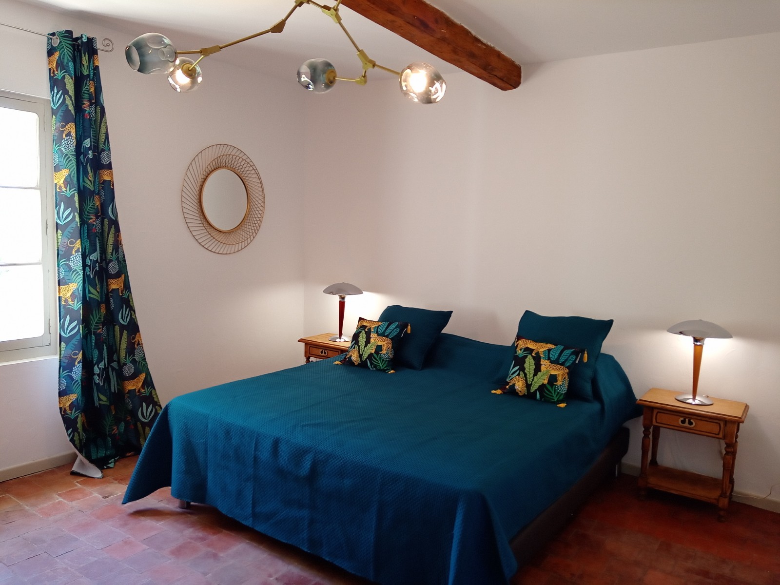 Ein im mediterranen Stil eingerichtetes Schlafzimmer mit einem großen Doppelbett, bedeckt mit